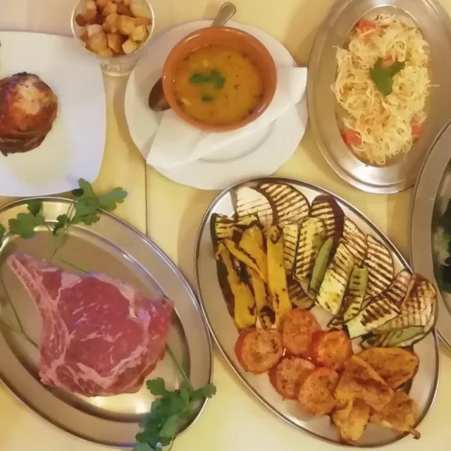 Overhead view of Bottega dishes with meat, grilled vegetables, soup and pasta.
