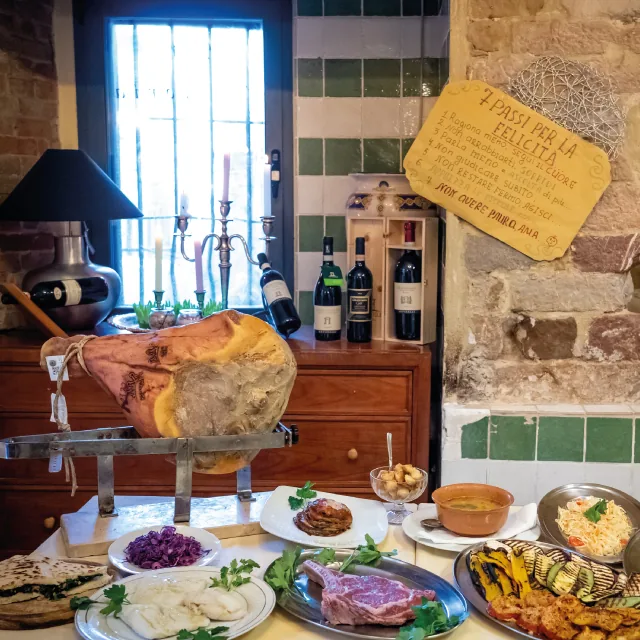 Table in the Bottega dining room with prosciutto, meat, grilled vegetables, torta al testo and dishes prepared in the kitchen.