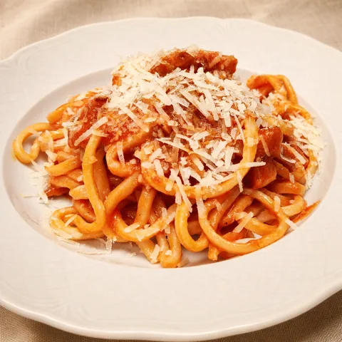 Umbricelli Amatriciana with tomato sauce and grated cheese.