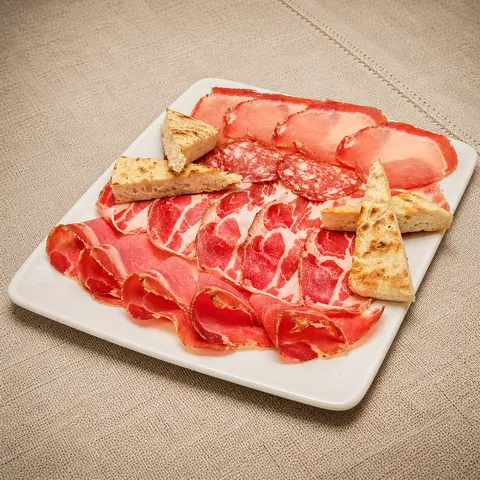 Selection of Umbrian cured meats on a rectangular platter with torta al testo.