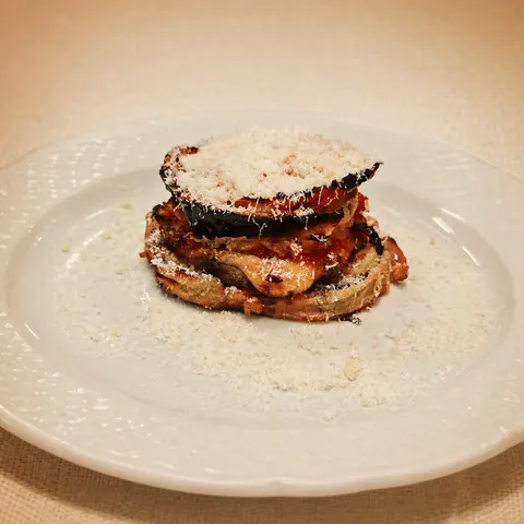 Aubergine parmigiana tart with tomato, basil and melted cheese.