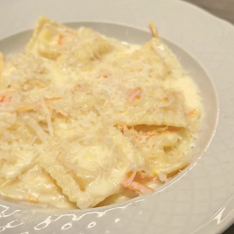 Filled ravioli with a creamy orange and parmesan sauce.