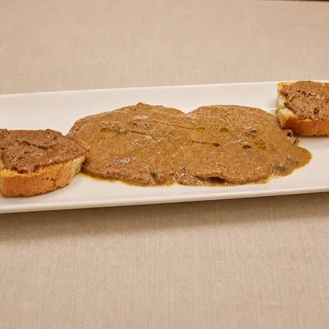 Torello alla Perugina on a rectangular plate with chicken-liver and caper sauce.